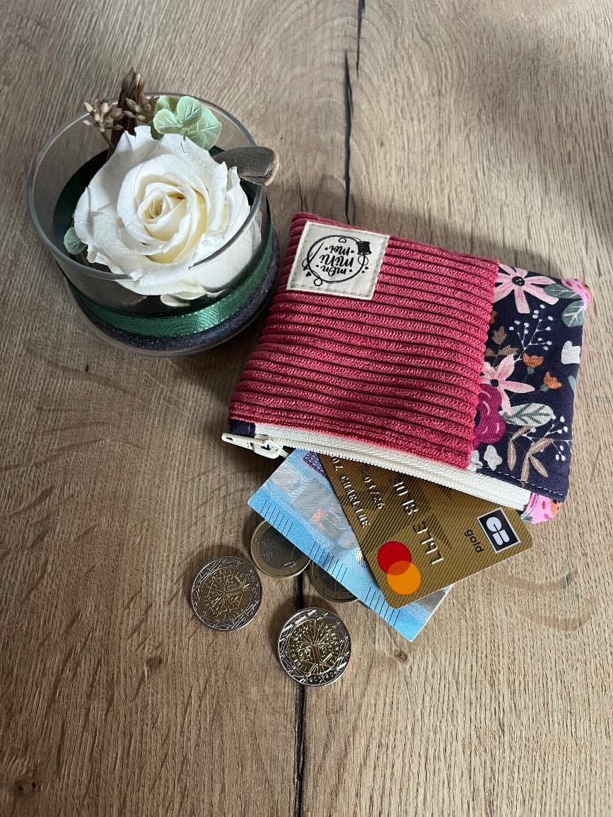 Vue du dessus du porte-monnaie zippé bicolore avec pièces et carte bancaire