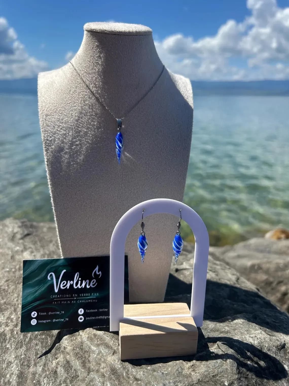 Collier coquillage bleu sur buste et boucles d'oreilles assorties présentées sur support en extérieur